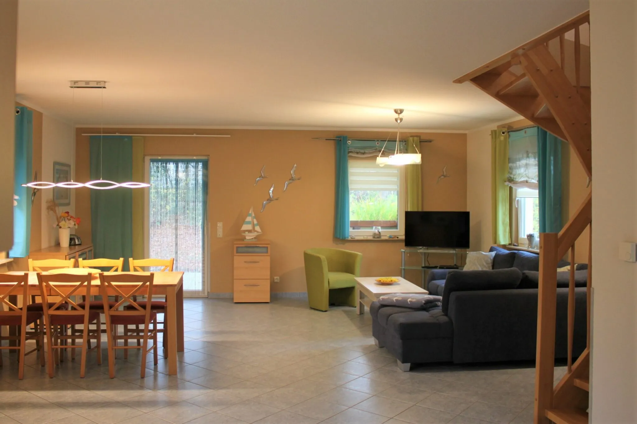 Offener Wohn- und Essbereich mit großem Holztisch und Terrassentür